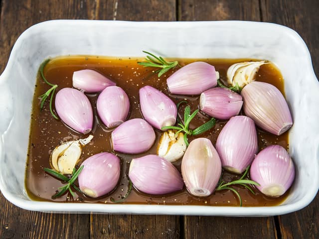 **Bakt løk:** Rens og skrell sjalottløkene. Legg dem hele i en ildfast form sammen med hele, knuste hvitløksfedd og rosmarinkvaster eller timian. Hell over kjøttkraft, salte og pepre.