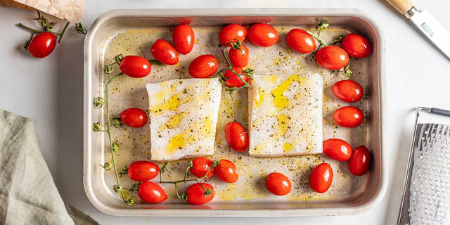 Skyll av saltet fra torskefiletene. Legg torsken over i en ildfast form med cherrytomater. Krydre med salt og pepper, og ringle over litt olivenolje.