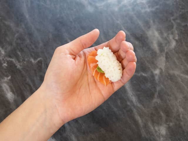 Legg litt wasabi på risballen og legg så fileten over risballen.
