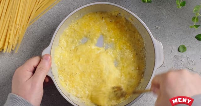 Pisk sammen egg, fløte og revet parmesan i en bolle. Kutt baconet i terninger og stek sprøtt i en stekepanne.