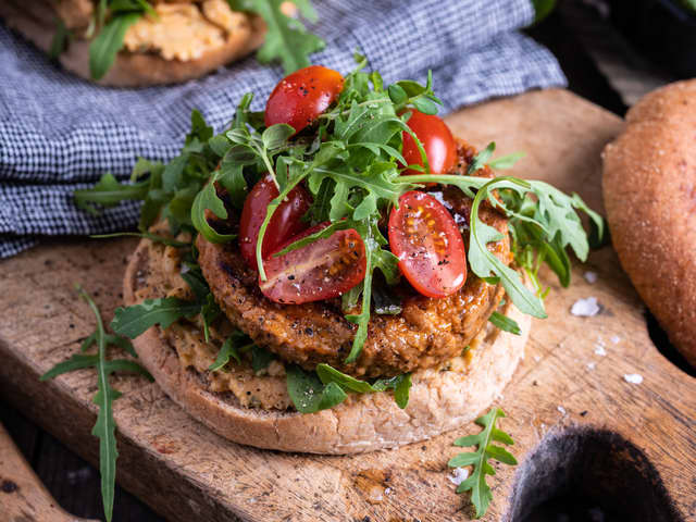 Del burgerbrødene i to og fordel hummus og halvparten av ruccolaen på nederste del. Legg på burgerne og topp med mer ruccola. Server!