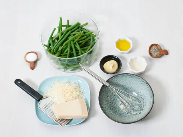 Riv parmesan. Finhakk hvitløk, bland dressingen og vend inn bønner og parmesan.