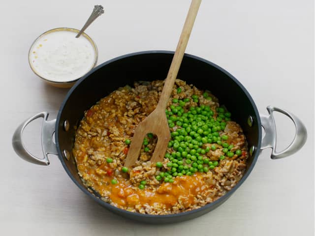 Tilsett kyllingkjøttdeig og stek til den skifter farge. Rør inn saus og erter. La småkoke i ca. 5 min.
