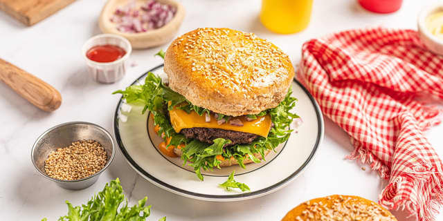 Pensle burgerbrødene med sammenpisket egg og strø over sesamfrø.
Stek hamburgerbrødene **midt i ovnen på 200 grader i ca 15 minutter** til de er gylne.