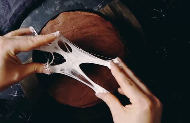 Ta en liten klump smeltet marshmellows på tuppen av fingrene. Dra hendene og fingrene fra hverandre så marshmellowsen strekker seg og blir lange, fine tråder.