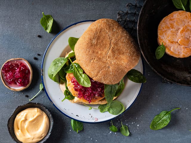 Del burgerbødene og legg spinat, lakseburger og syltet rødløk på nederste del. Legg på lokket og server.