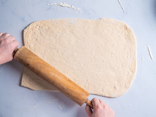 Del deigen i to, og legg den ene deigen tilbake på benken med mel og kjevle den ut til en rektangel som er ca 30x60 cm.