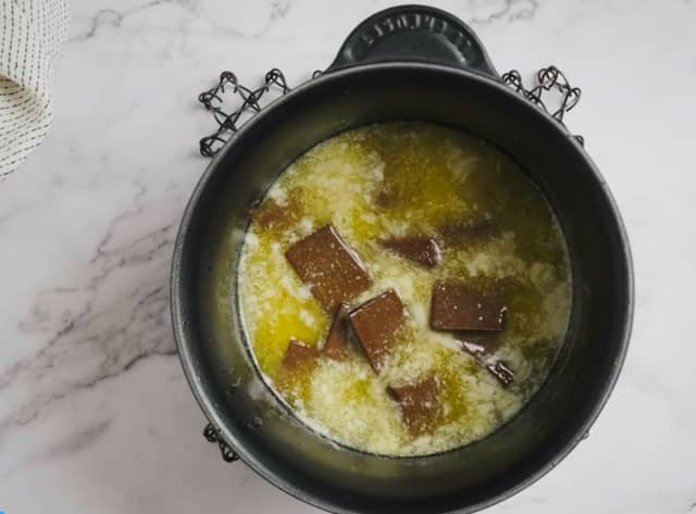 **Kakebunn:** Hakk sjokoladen i grove biter. Smelt smøret på medium varme i en kjele, trekk til side og ha så i sjokoladen. La sjokoladen smelte i smøret. Rør innimellom.