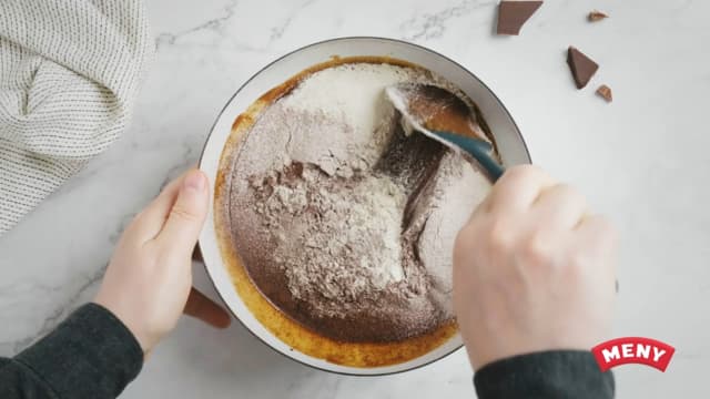Sikt melet, vaniljesukker og kakaoen over i bollen og vend det inn med en slikkepott.