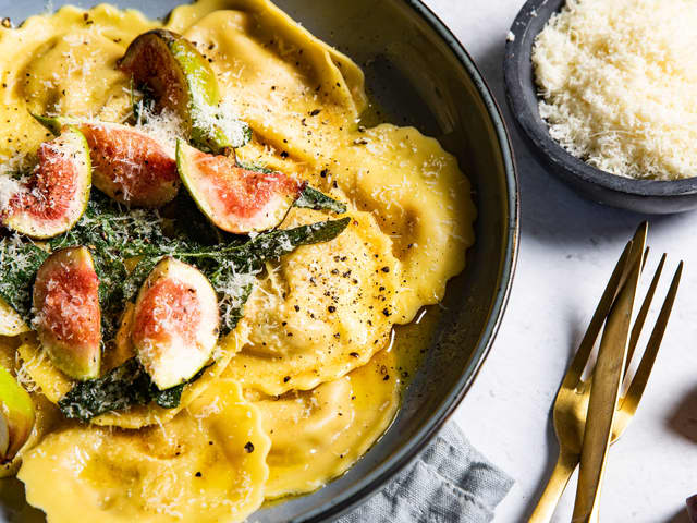 Anrett ravioli på to tallerkener og topp med salviesmør og fiken.
