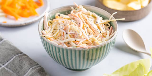 Smak til med salt og pepper, vend dressingen inn med kål, eple og gulrot og server.