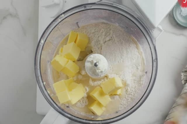 Dersom du bruker foodprosessor har du alle ingrediensene oppi og kjører til en deig. Smøret skal da være i terninger. Kna denne raskt sammen.