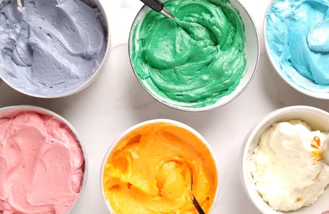 **Regnbue-frosting:** Fordel smørkremen i boller og bland inn ulike konditorfarger. Ha de ulike fargene over i hver sin sprøytepose.