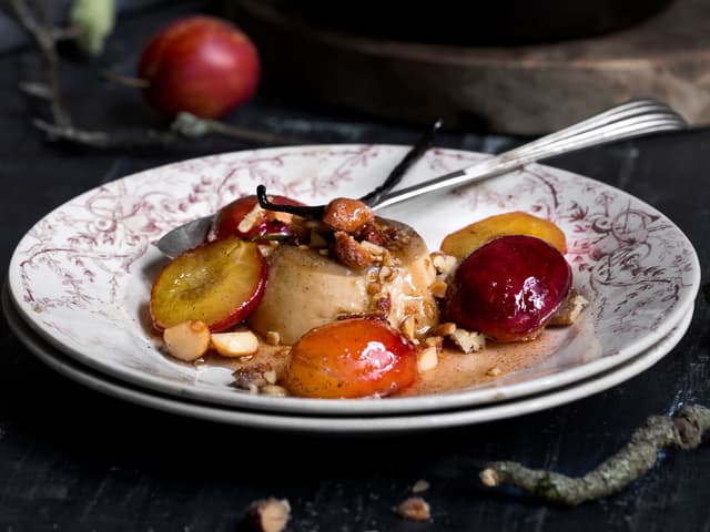 Server kaffe-panna cotta med stekte plommer, sausen fra pannen og hakket Honey Roasted nøttemix.