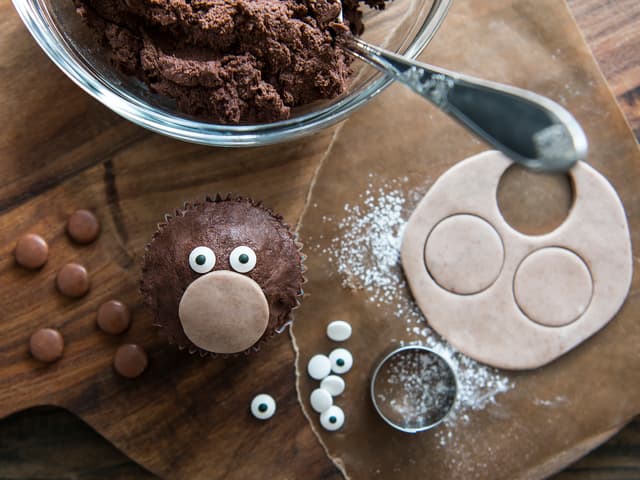 Pynte apekatt: Smør cupcaken med sjokoladefrostingen. Hull ut en sirkel i fondant som nesen.