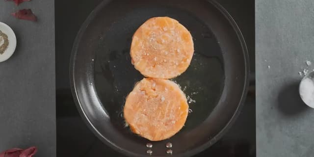 Krydre lakseburgerne med salt og pepper. Stek dem i litt olje til de er gylne og såvidt gjennomstekt. Dette tar ca. 1-2 minutter på hver side.