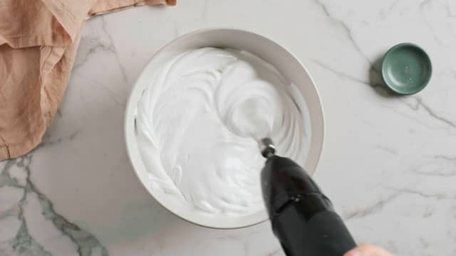 Når massen er stiv og luftig tilsetter du sukkeret litt etter litt. Pisk til marengsen er blank og fast.