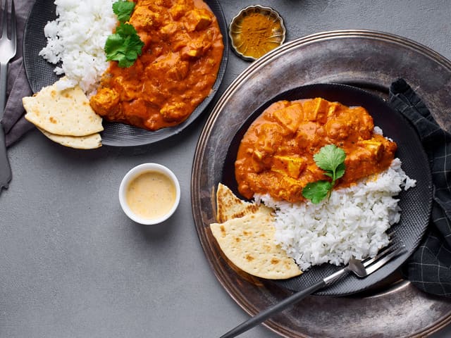 Anrett tikka masala, brød, raita og salat på tallerkener. Server.