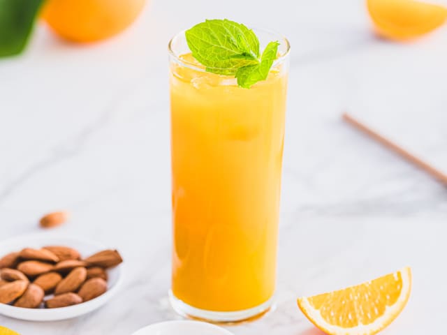 Hell appelsinjuicen i blenderen, ha i gurkemeie og halvparten av isbitene. Kjør blenderen til det er godt blandet.