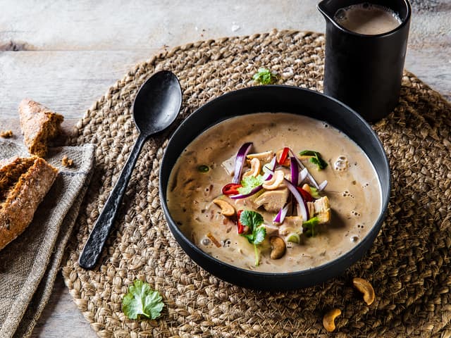 Fordel kylling, cashewnøtter, rødløk, chili og vårløk i hver suppebolle og ha over varm suppe. Dryss gjerne frisk koriander over suppen like før servering.
