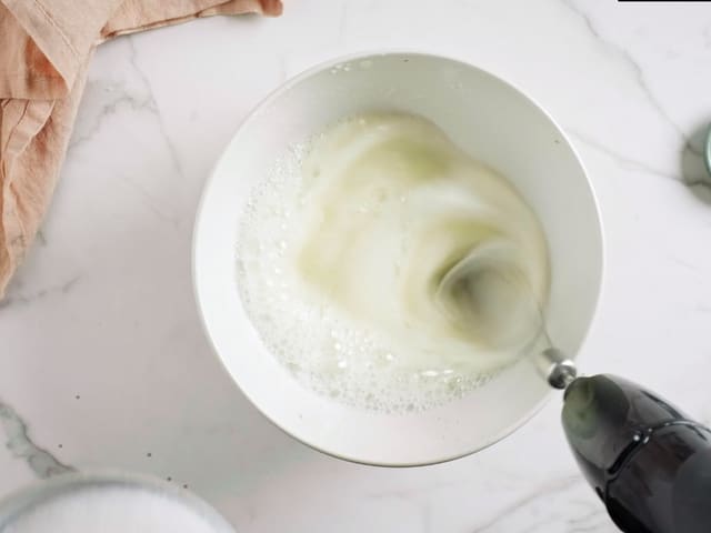 Ha eggehvittene i en helt ren bolle uten noen fettrester. Pisk eggehvittene med 2 ss av sukkeret. Start på lav hastighet, og pisk til det begynner å skumme.