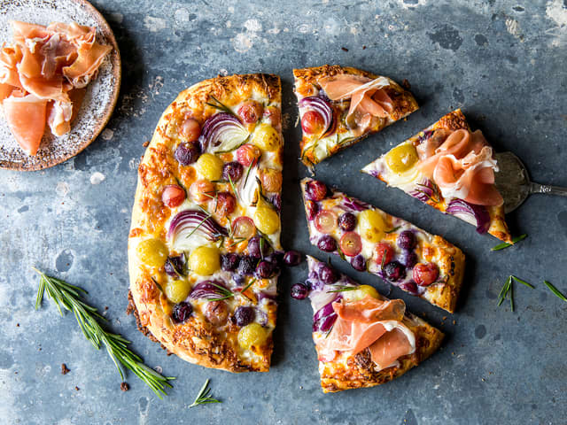 Hvit pizza med druer og spekeskinke