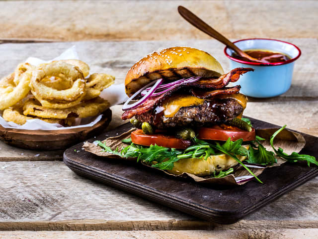 Baconburger toppet med bacon og løkringer