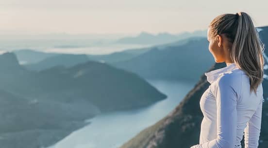 Foto av en sprek jente med norsk fjord i bakgrunnen