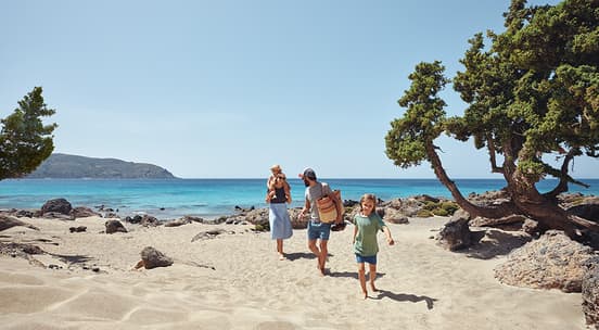 Familie som løper på stranden og ler