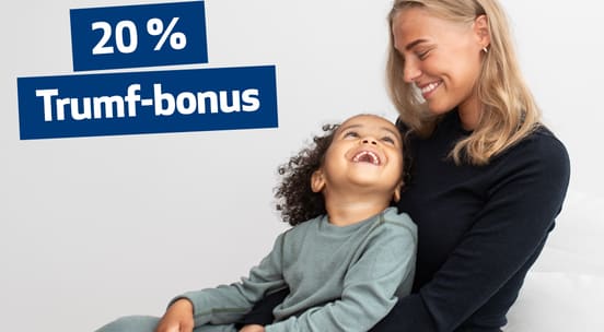 Foto av mor som smiler ned på barnet sitt, begge ikledd ull fra topp til tå