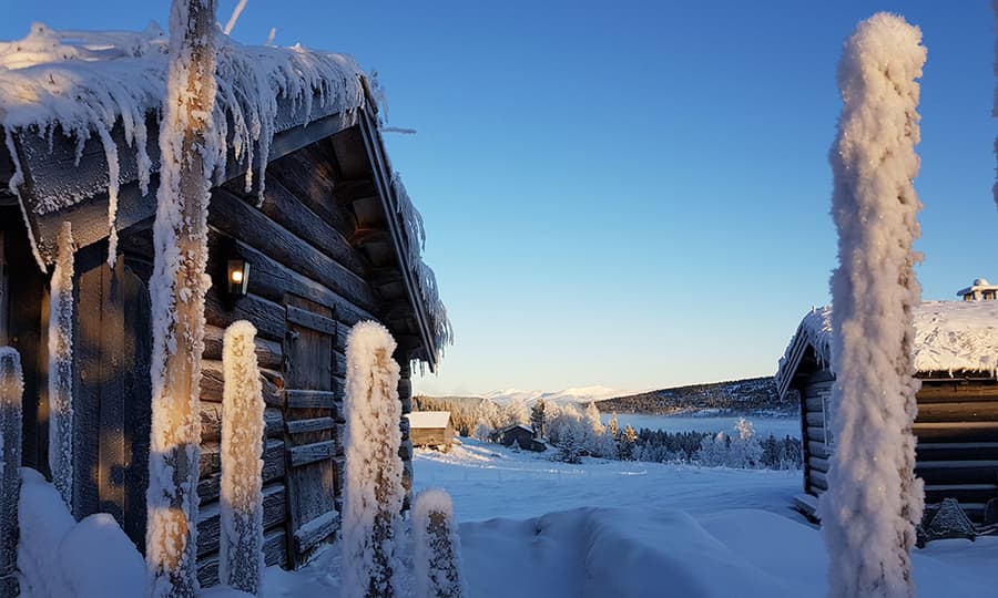 hytte badet i snø og sol