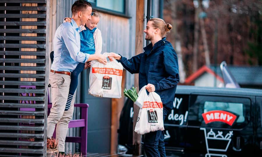 Ansatt i MENY som leverer varer fra MENY nettbutikk på døren til kunde