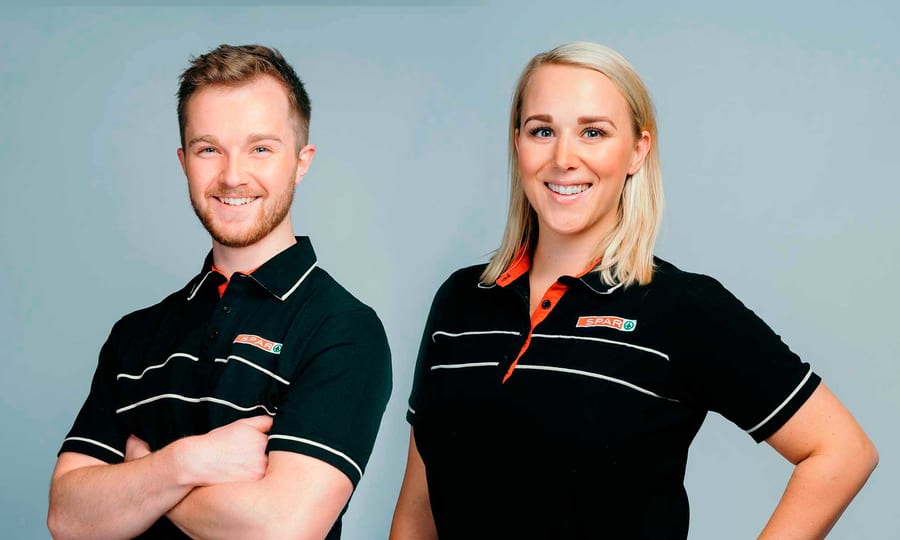 Mann og dame i SPAR-uniform som smiler mot kamera