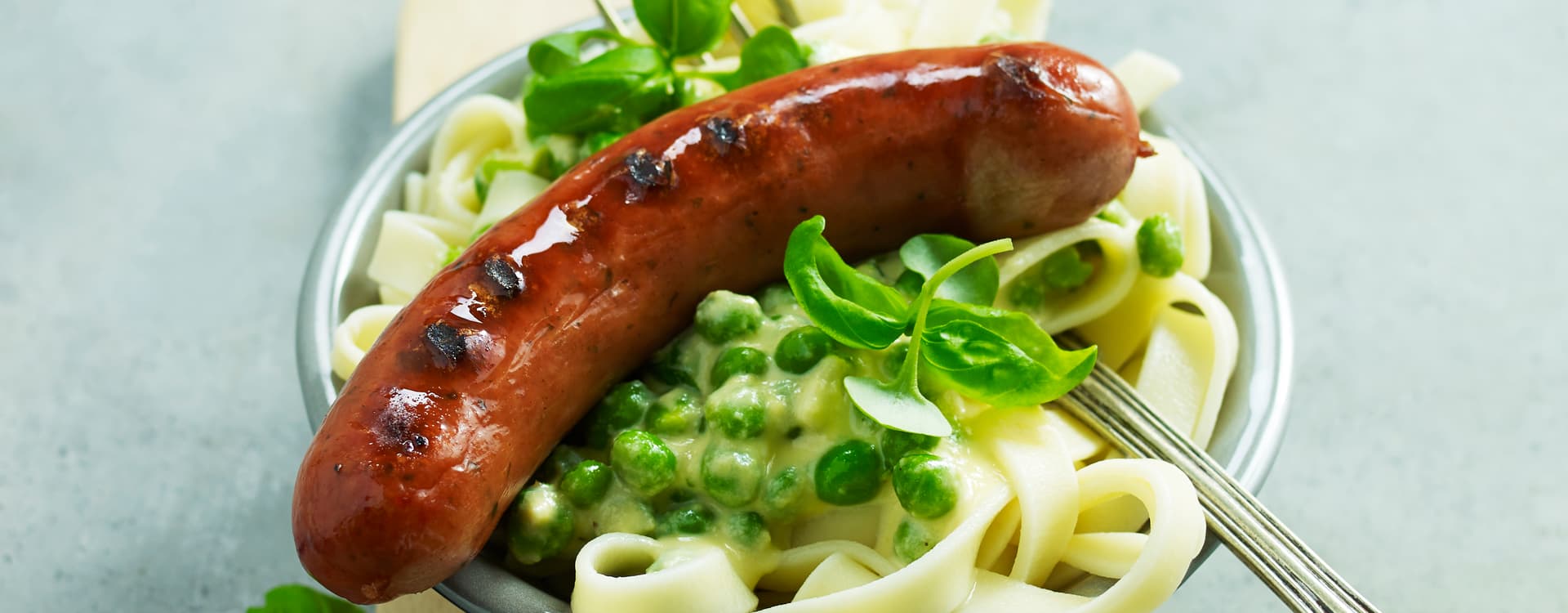 Pølse med kremet tagliatelle, erter og persille
