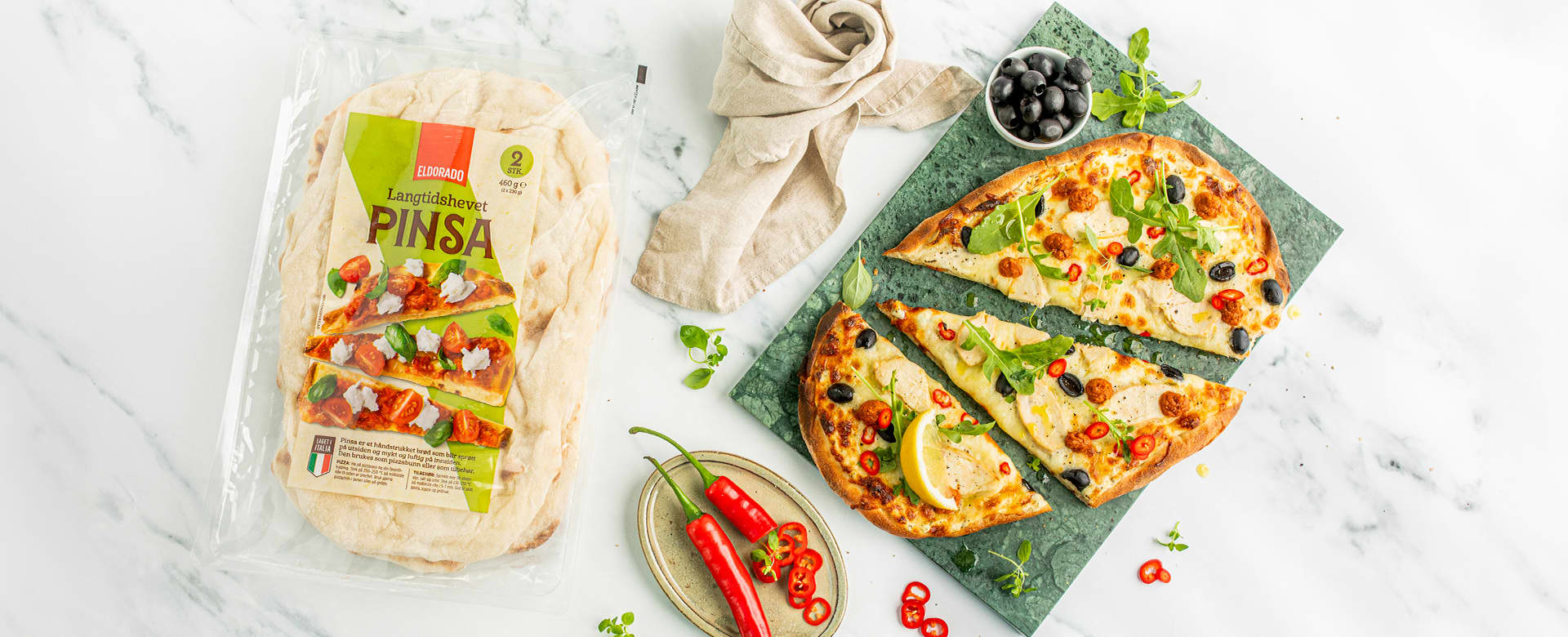 Pinsa i forpakning og tilberedt med topping ved siden av