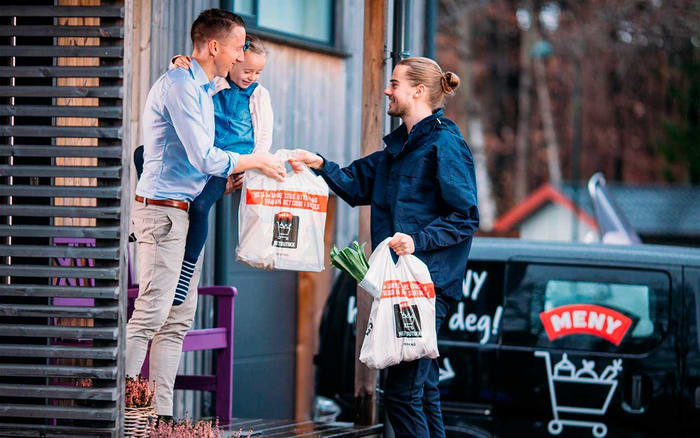 Ansatt i MENY som leverer varer fra MENY nettbutikk på døren til kunde