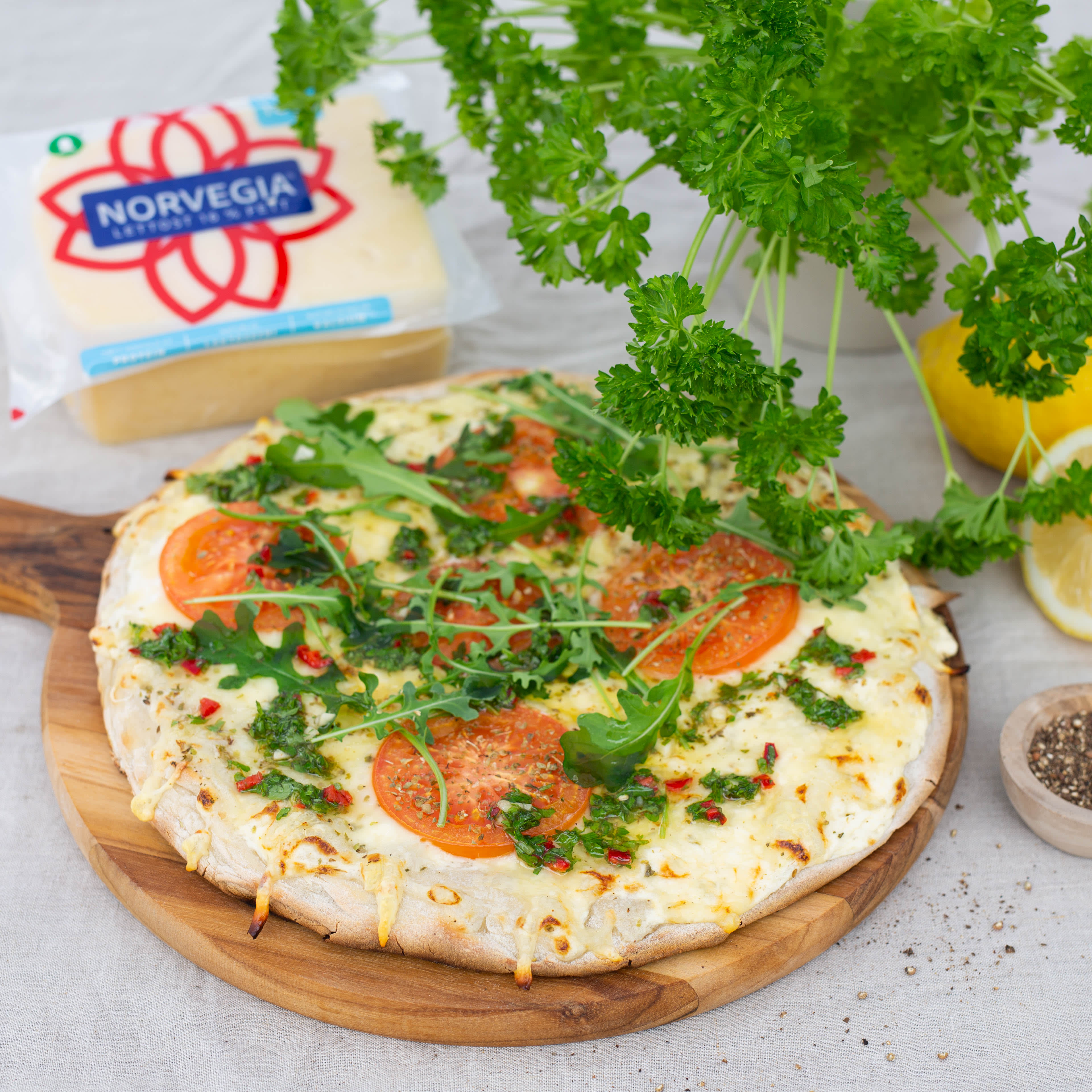 Grillet pizza med hvit saus, tomat, ruccula og urtesaus