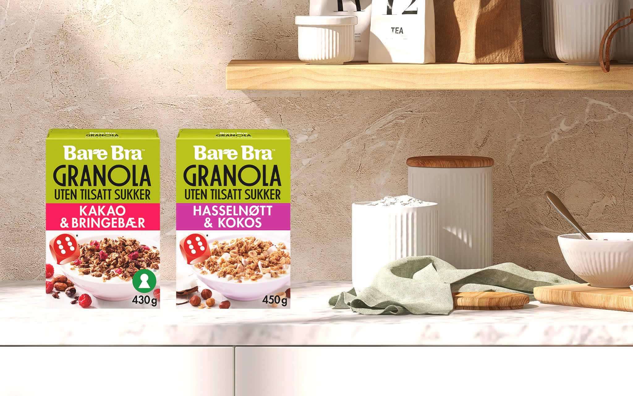 Bare Bra Granola Kakao & Bringebær og Bare Bra Granola Hasselnøtt & Kokos på en kjøkkenbenk