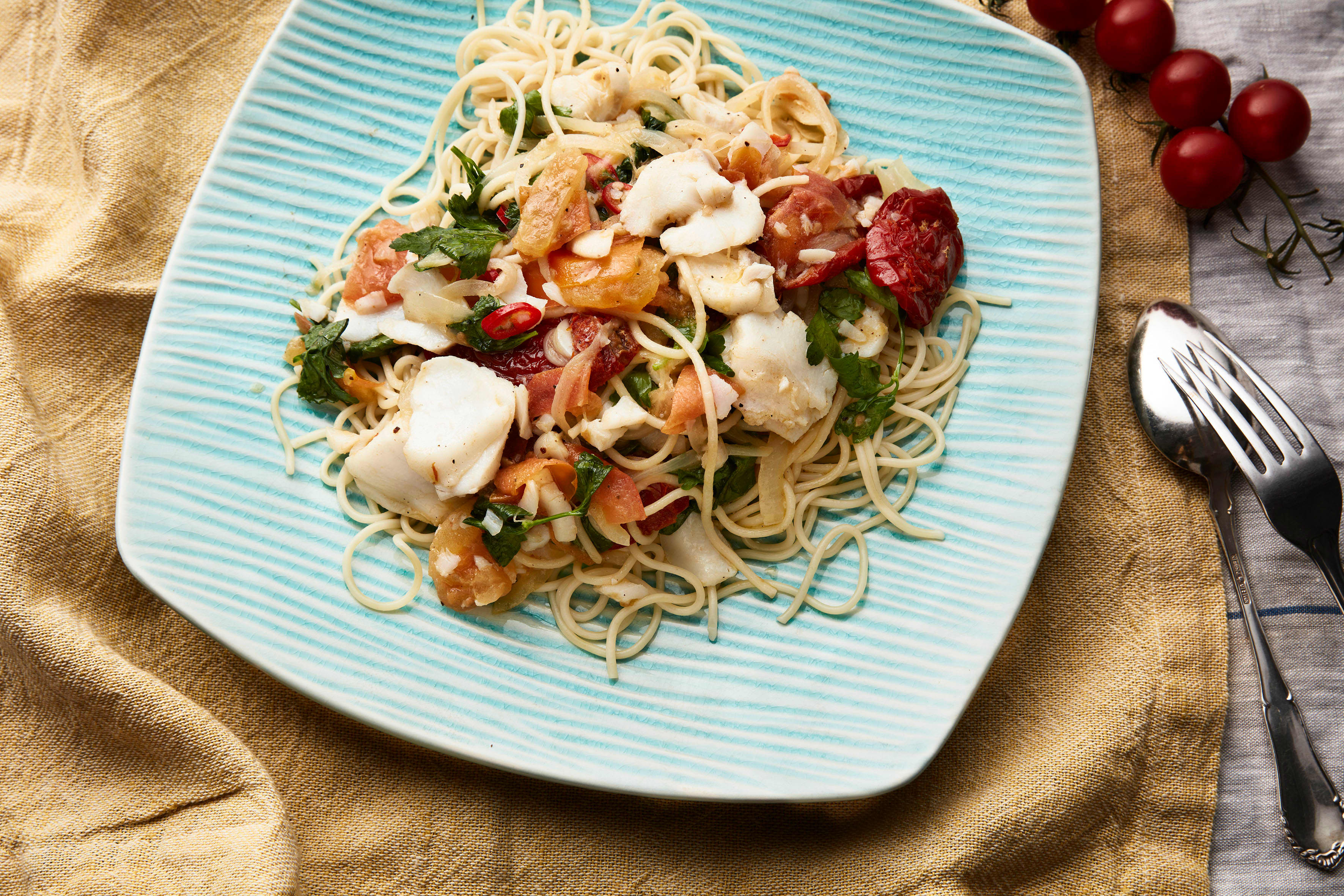 Tallerken med spagetti med torsk, olivenolje og soltørkede tomater