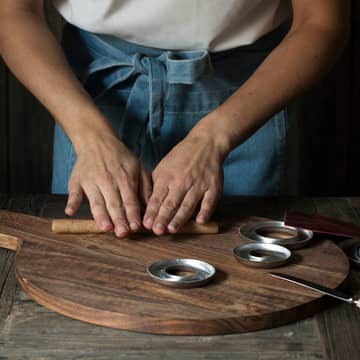 Rull fingertykke pølser som legges i smurte kransekakeformer