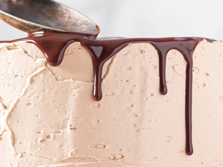 Siden kaken er kald og ganachen har blitt kaldere, vil sjokoladedråpene stoppe midt på kaken. 