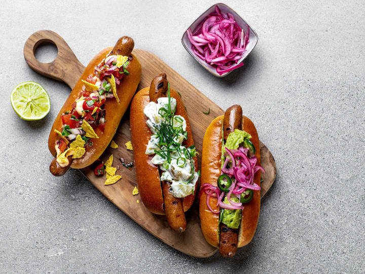 Varier pølsene med ulike pølsebrød og topping som syltet rødløk, potetsalat, frisk salsa og guacamole.