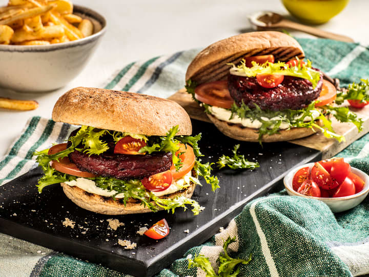 Server en smakfull vegetarburger i grove burgerbrød, toppet med salat og aioli. 