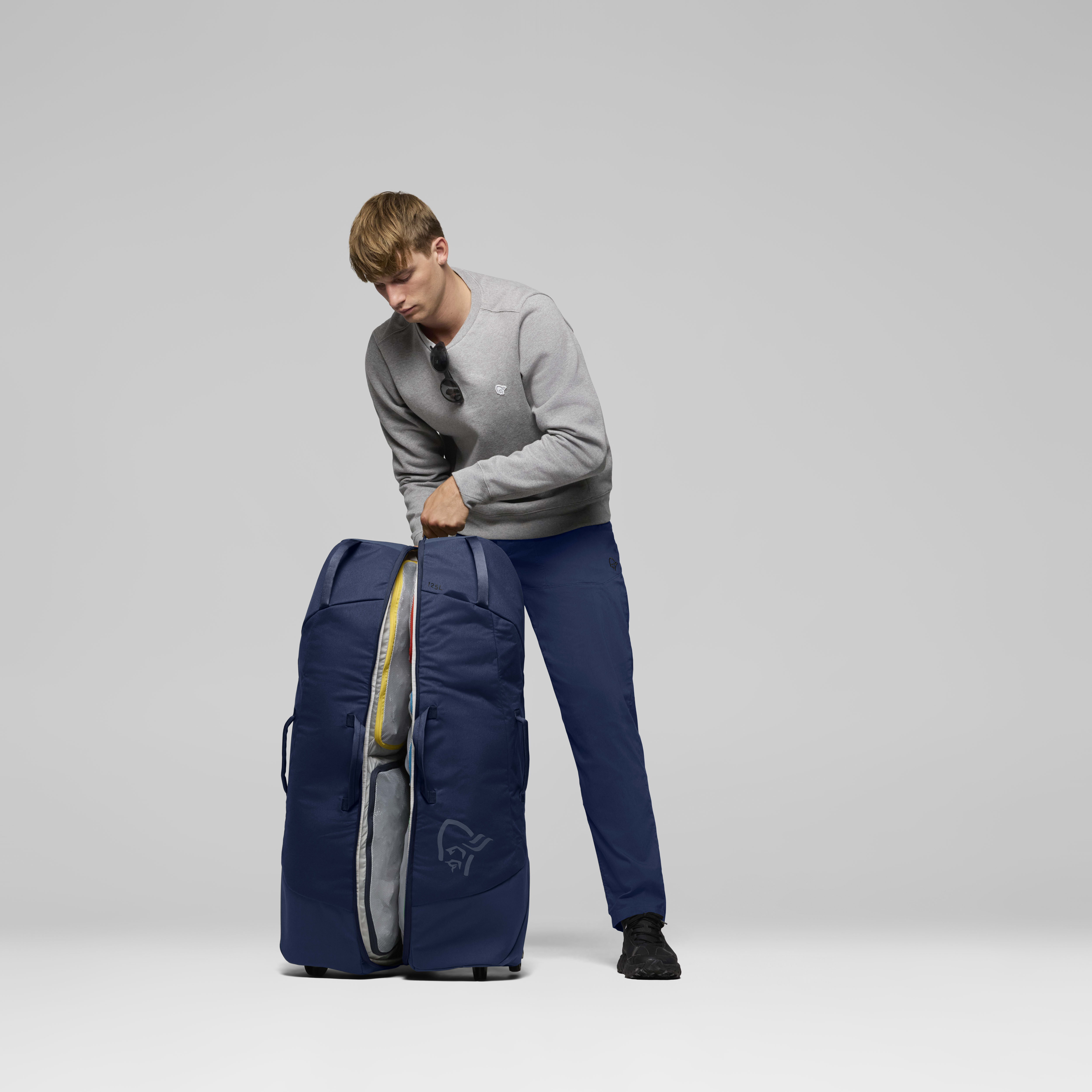 Female Look back image of norrona dividable 125L Trolley Bag Indigo Night