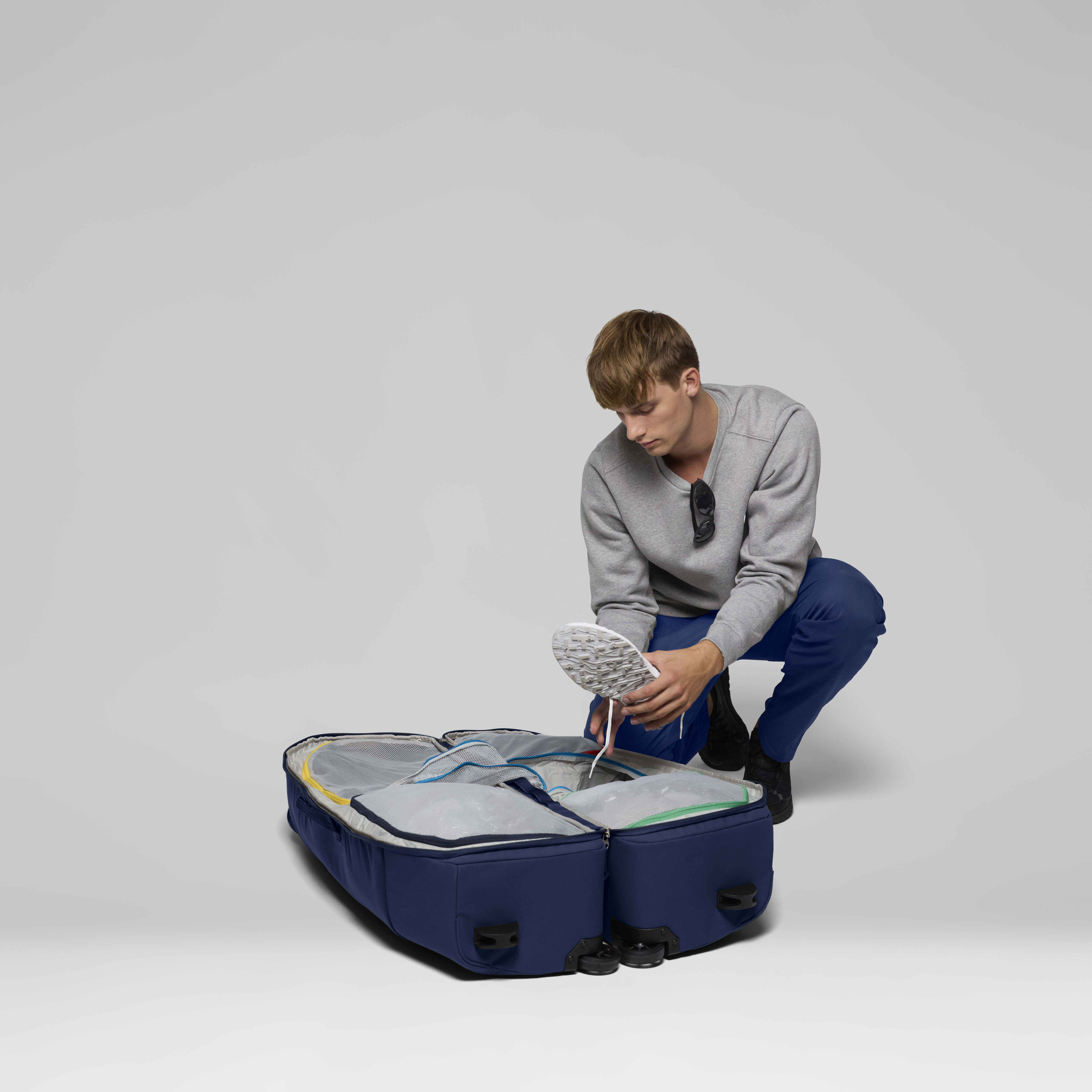 Female Look back image of norrona dividable 125L Trolley Bag Indigo Night