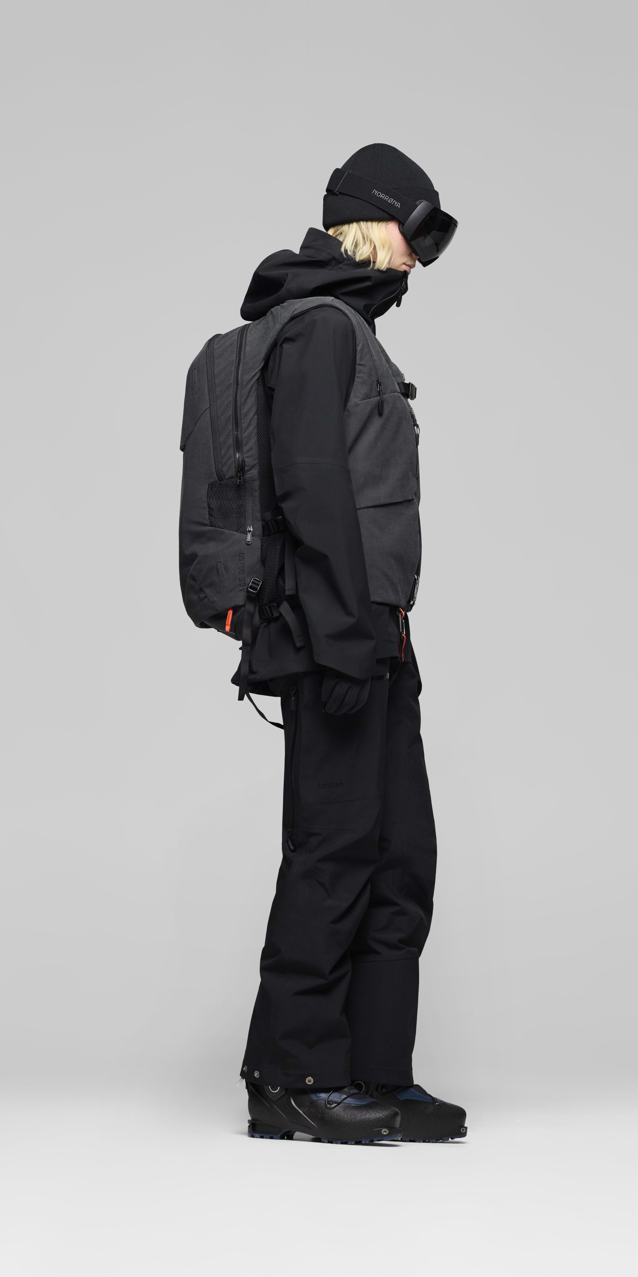 Female Look back image of lofoten Avi ACE 15L Pack Caviar Black