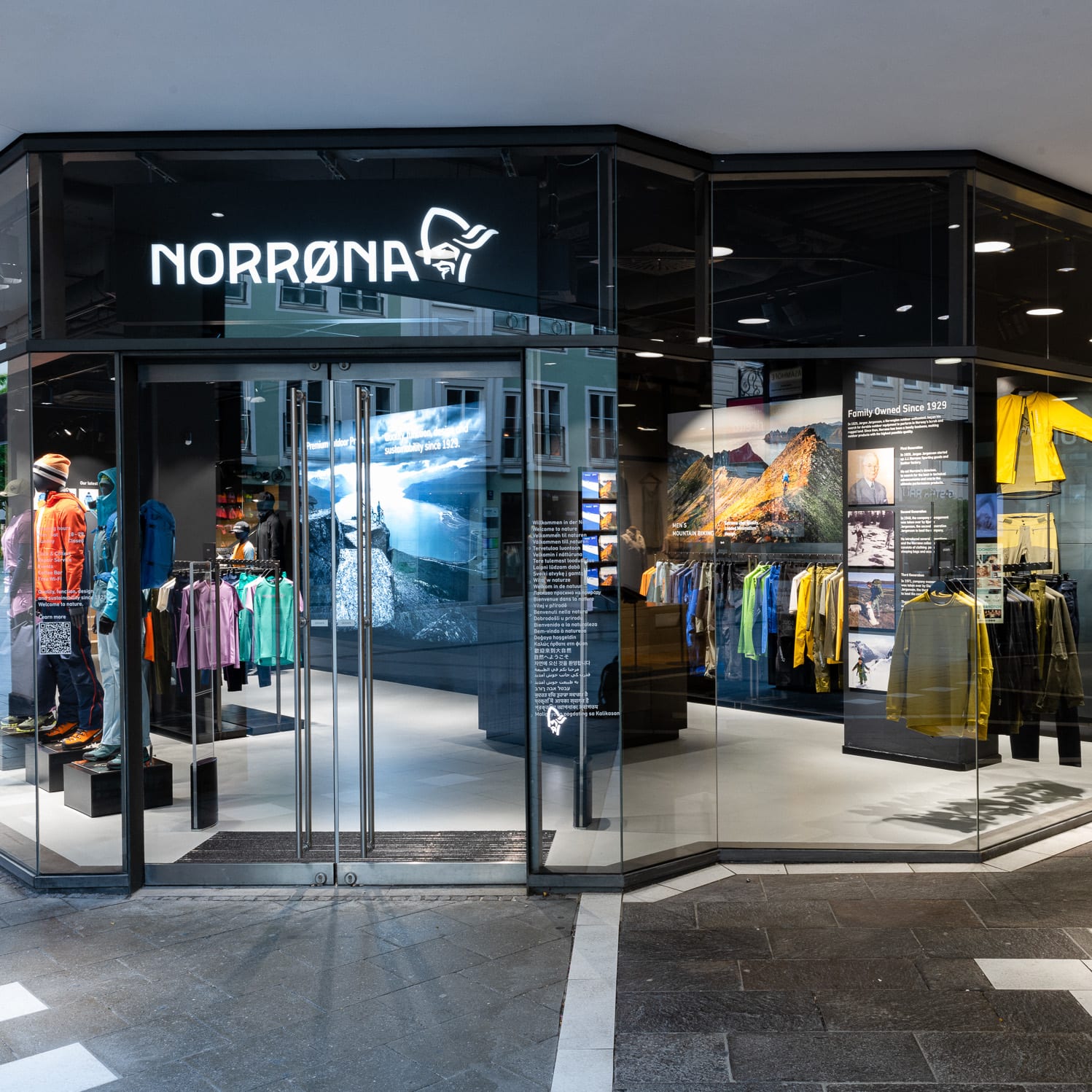 A storefront for Norrøna, an outdoor clothing brand, with mannequins wearing Norrøna clothing and a display of  Norrøna products inside. 
