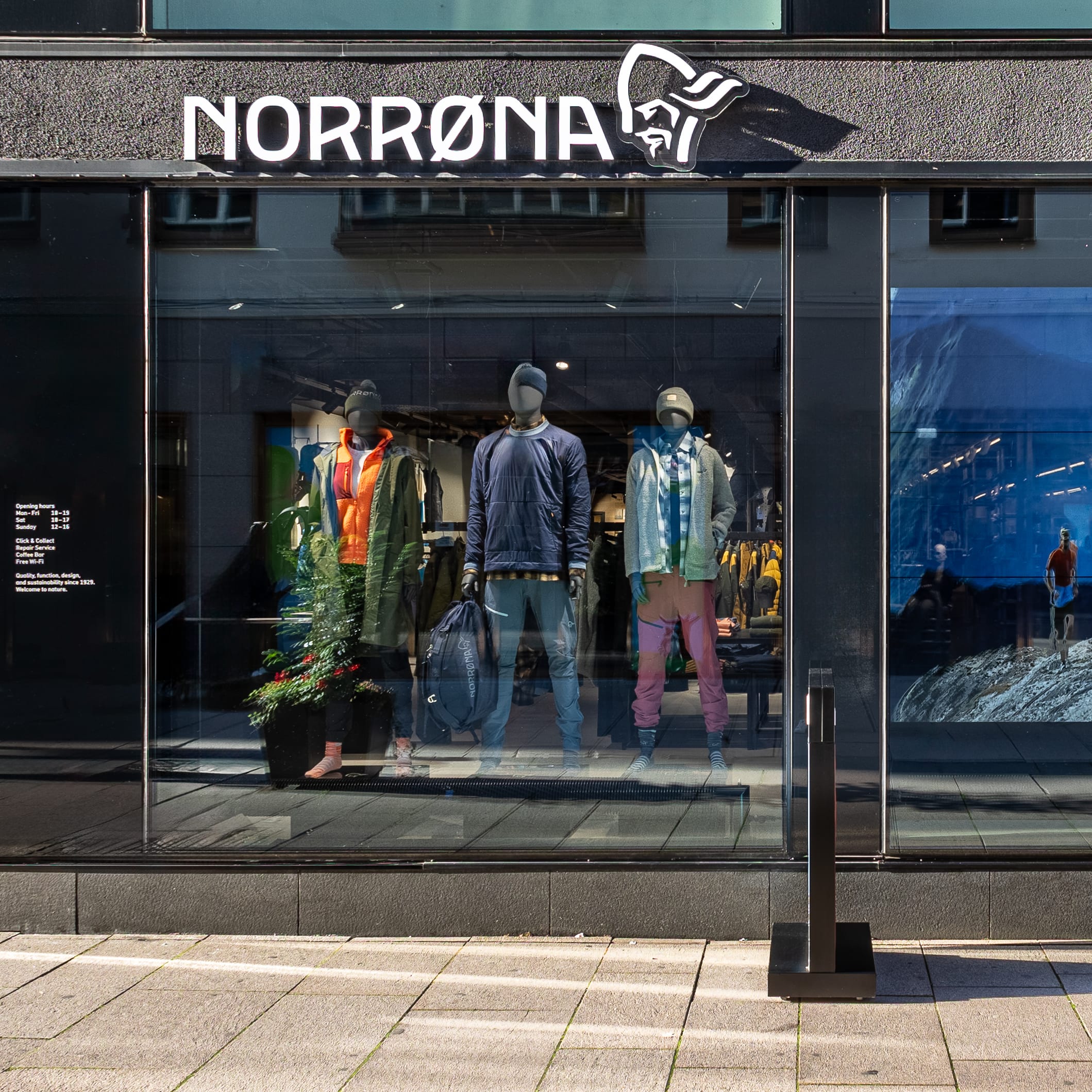 Storefront of Norrøna, featuring mannequins wearing Norrøna clothing and outdoor scene video display in the window.