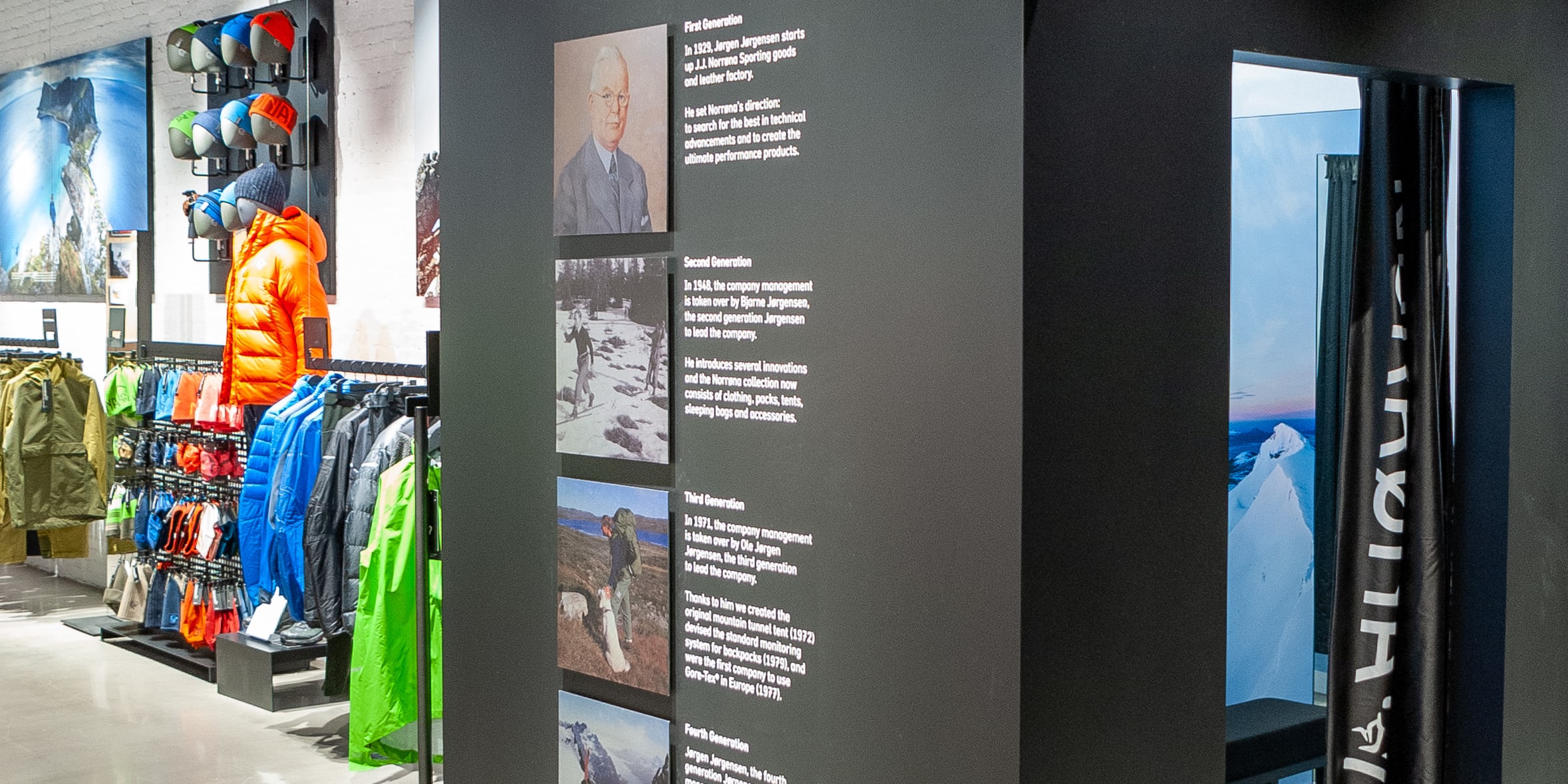 A Norrøna store interior with a display about the company's history, including photos of company founders, and a fitting room. 
