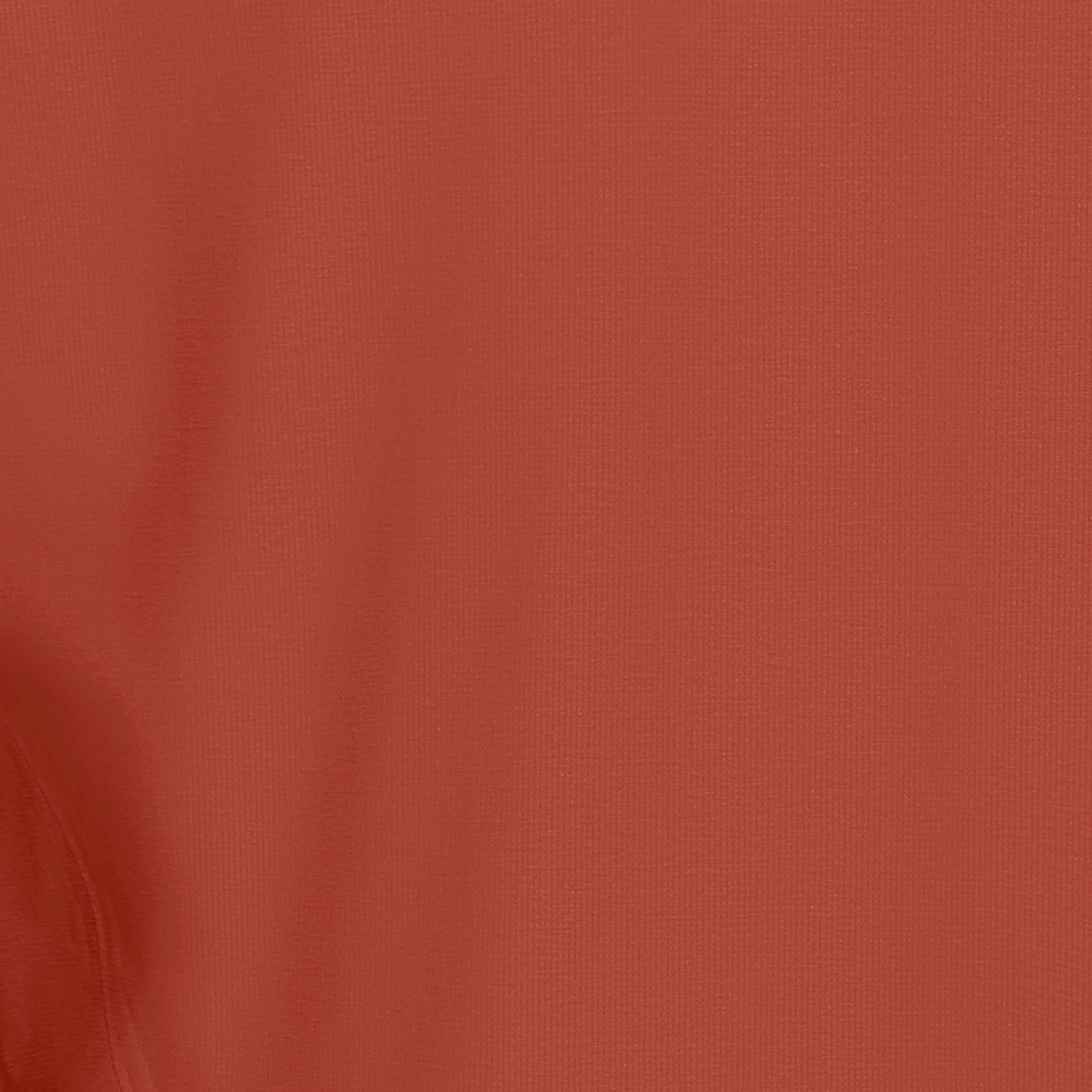 Close-up of the textured fabric of a Norrøna garment in a rust color.